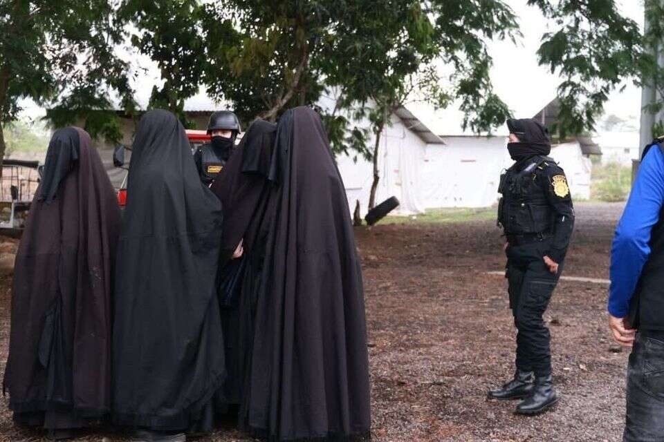 נשות כת לב טהור לצד השוטרים במהלך הפשיטה בגואטמלה , ללא
