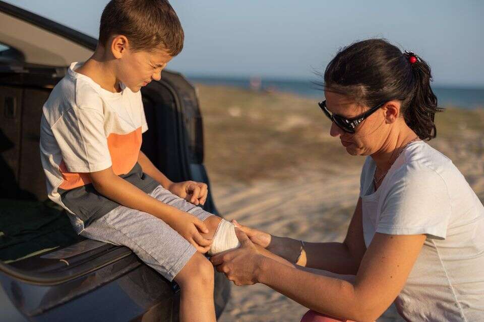 אם מטפלת בפציעת ילד בטיול , istockphoto