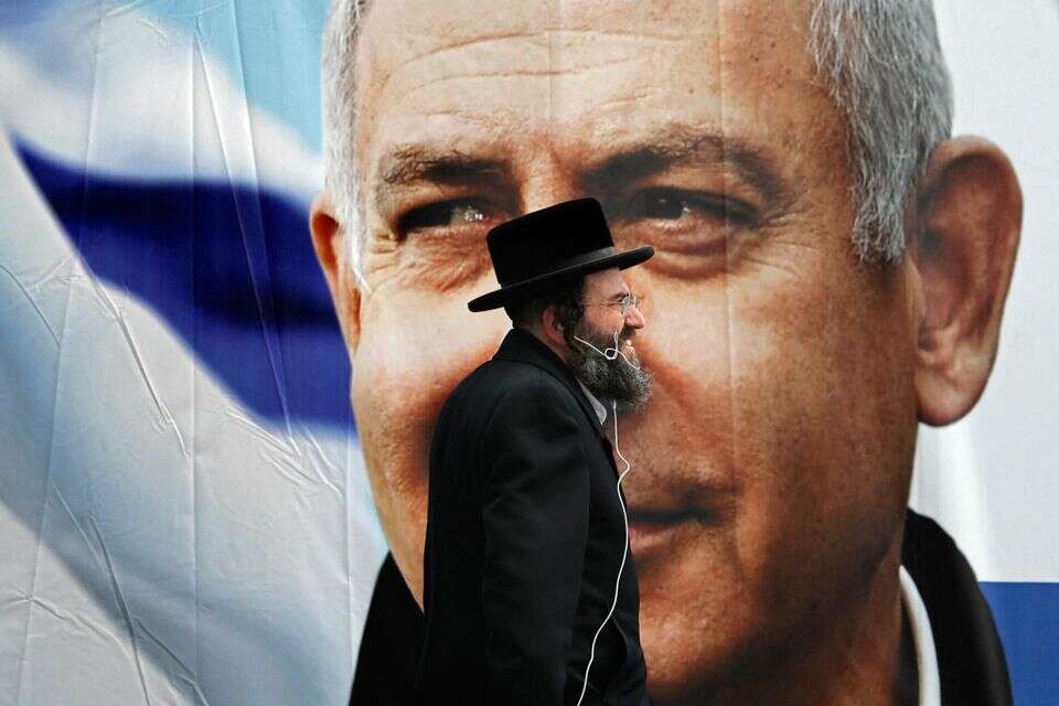 חרדי על רקע תמונתו של רה"מ נתניהו , אי.אף.פי