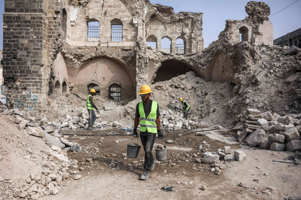 המעורבות הגוברת של טורקיה ברצועה היא תמרור אזהרה. פועלים עובדים בין ההריסות בעזה , אי.אף.פי