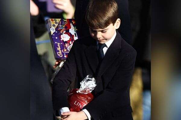 הנסיך לואי מחזיק שוקולד שקיבל בטקס חג המולד המסורתי של משפחת המלוכה באחוזת סנדרינגהאם במזרח אנגליה, ב-25 בדצמבר 2025 , Henry NICHOLLS / AFP