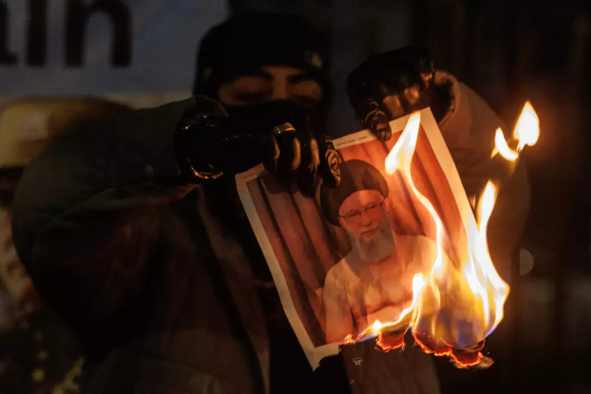 על הכוונת של טראמפ. מפגינים שורפים תמונה של חמינאי , GettyImages