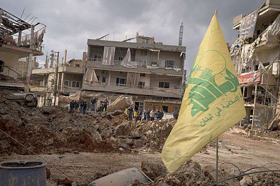 דגל חיזבאללה על רקע מבנה הרוס בלבנון , GettyImages