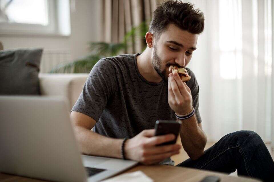אכילה עם הטלפון , istockphoto
