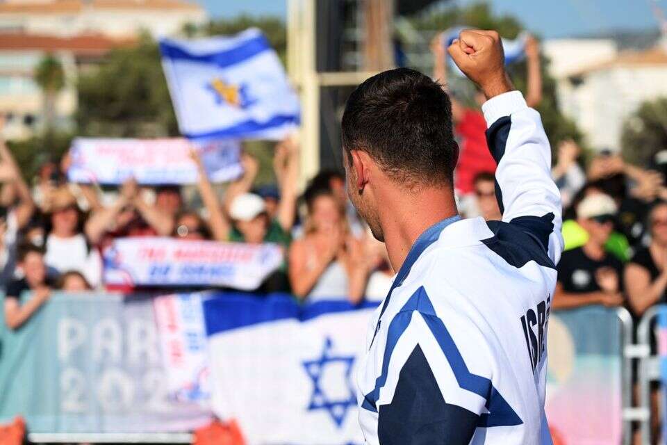 תום ראובני ודגלי ישראל ברקע , Getty Images