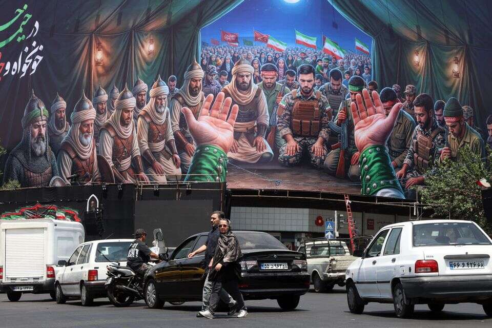 אזרחים איראנים חולפים על פני שלט חוצות בטהרן , EPA