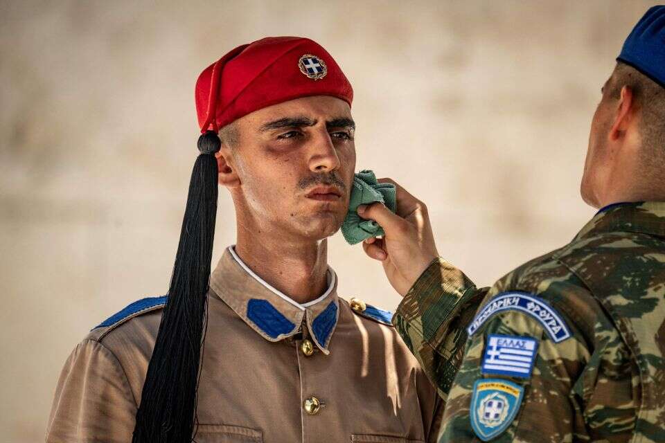 חייל מנגב את הזיעה מפניו של חייל משמר הנשיאות היווני באתונה, אתמול , AFP