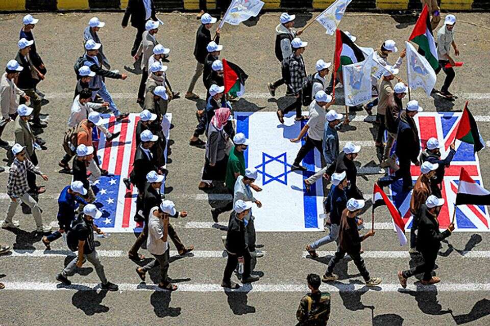 סטודנטים בצנעא דורכים על דגלי ישראל וארה"ב  , AFP