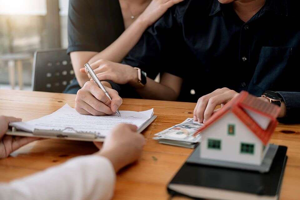 Real estate agent offer hand for customer sign agreement contract signature for buy or sell house. Happy asian couple signing a contract together at office. Real estate contact agreement concept. , GettyImages