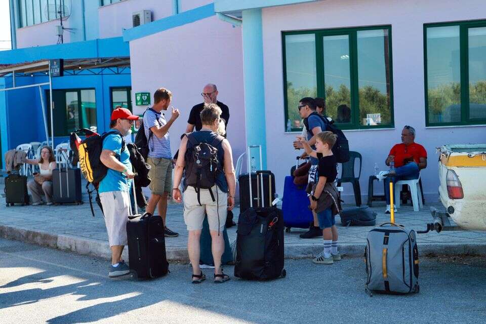 epa13141574 Tourists wait to be transferred to the Moires Indoor Sports Hall in Heraklion, Crete Island, Greece, 30 July 2026, during an evacuation operation due to a wildfire that broke out on 29 July in Krya Vrysi, Rethymno, Crete. Firefighters continued to battle the remaining wildfire front in the Agia Paraskevi area of southern Rethymno on 30 July, although the overall situation had improved significantly.  EPA/NIKOS CHALKIADAKIS , EPA/NIKOS CHALKIADAKIS