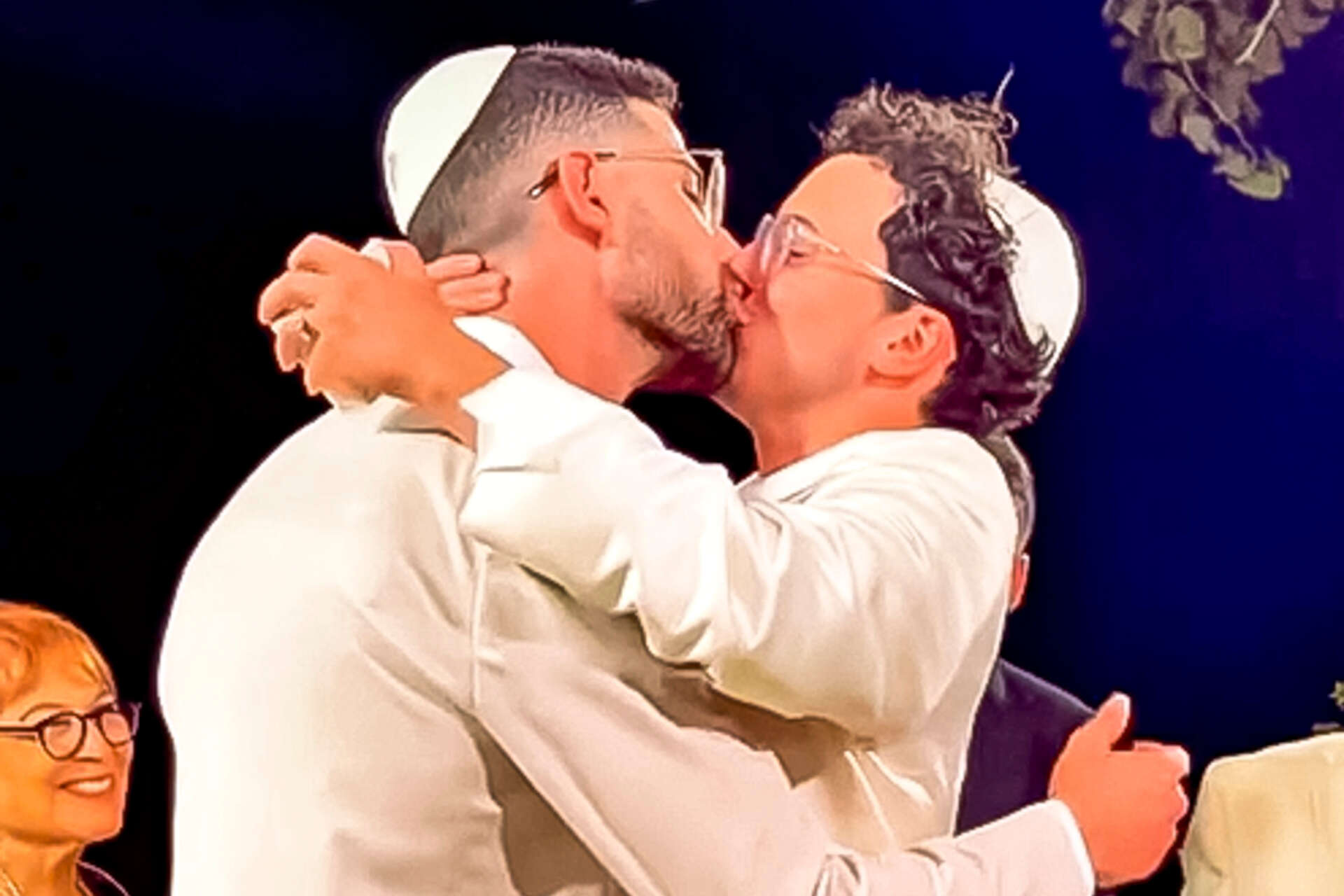 שחר טבוך ואמיר אהרון מתנשקים בחליפות חתן לבנות מתחת לחופה, 9 באוגוסט 2025 , מתוך סרטון בעמוד האינסטגרם של שחר טבוך