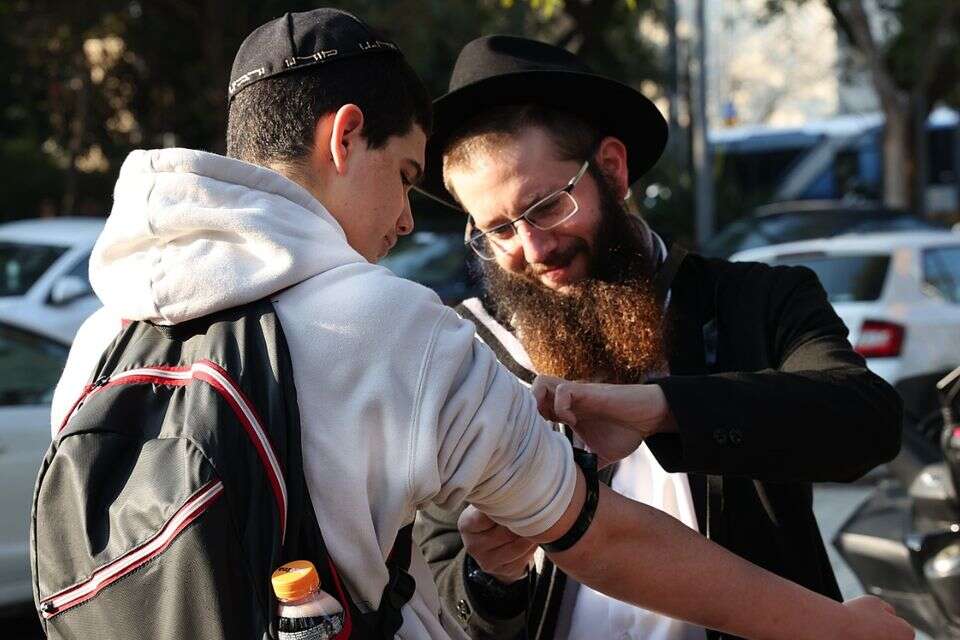 שליח חבד מניח תפילין לתלמידים בכניסה לבי״ס אליאנס ברמת אביב , קוקו