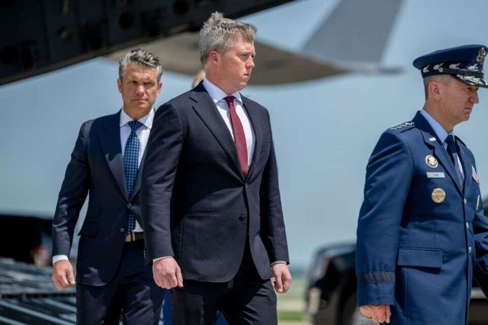 מזכיר הצבא דן דריסקול, בעניבה אדומה, לצד שר ההגנה פיט הגסת', משמאל , בלומברג