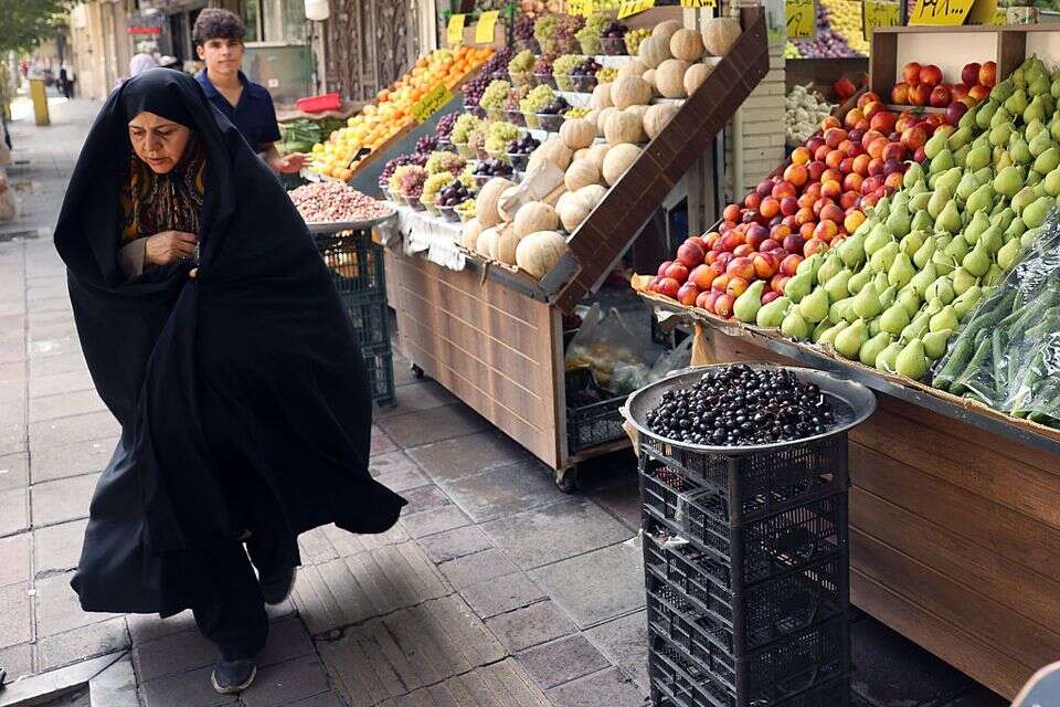 אישה חולפת בשוק בטהרן בירת איראן , אי.פי.איי
