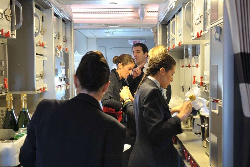 Air France crew members work in the cabin of the first Air France A380 during its flight from the Airbus plant in Hamburg to Paris' Roissy airport on October 30, 2009. Air France became the first European airline to take delivery of the new Airbus A380 superjumbo passenger jet, which it says will make it great savings in tough economic times. AFP PHOTO ERIC PIERMONT ,