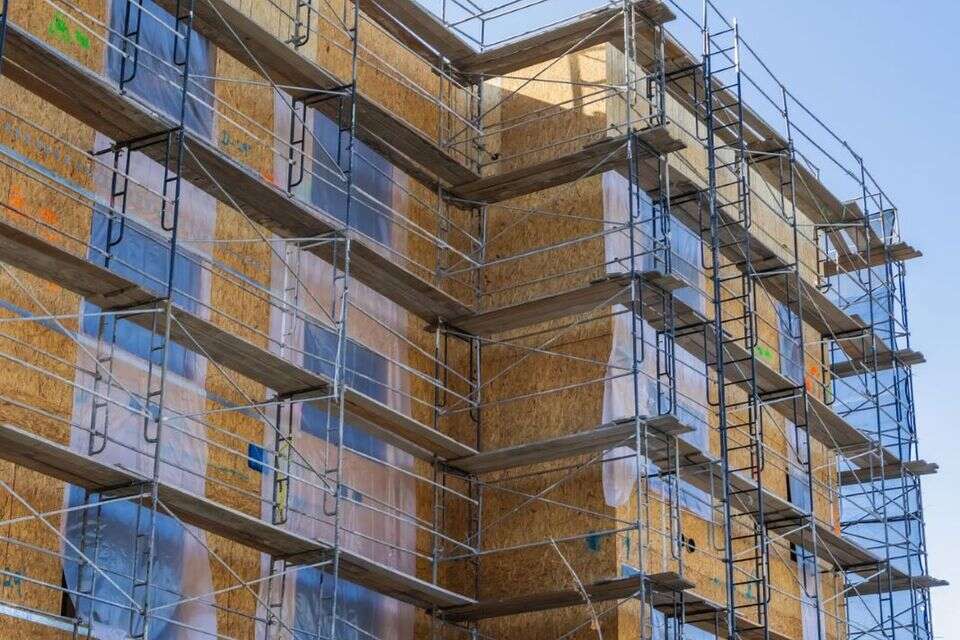 Building renewal in progress. A high-rise building covered in scaffolding during construction and repair work under clear skies. (Illustration) , pexels