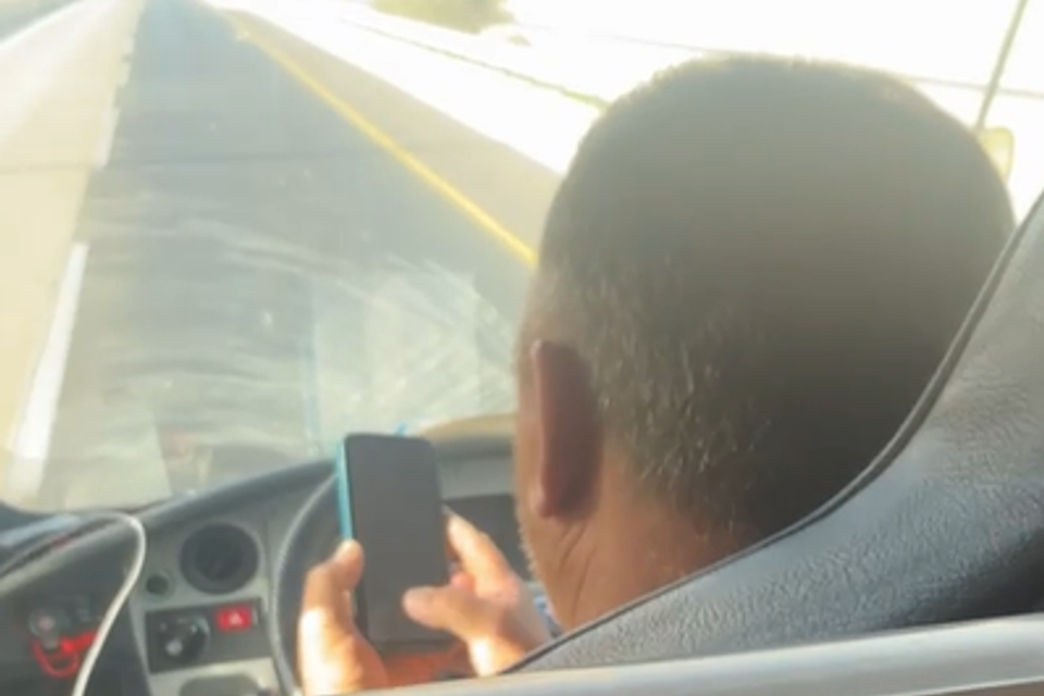 הנהג מחזיק את הנייד בשתי ידיים בלי לגעת בהגה , ללא