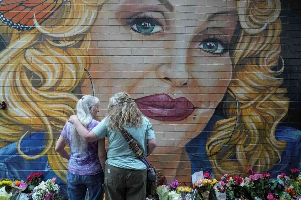 People gather by a mural to pay their respects to late country singer Dolly Parton a day after her death was announced, in Knoxville, Tennessee, U.S., August 26, 2026. REUTERS/Megan Varner TPX IMAGES OF THE DAY , REUTERS/Megan Varner