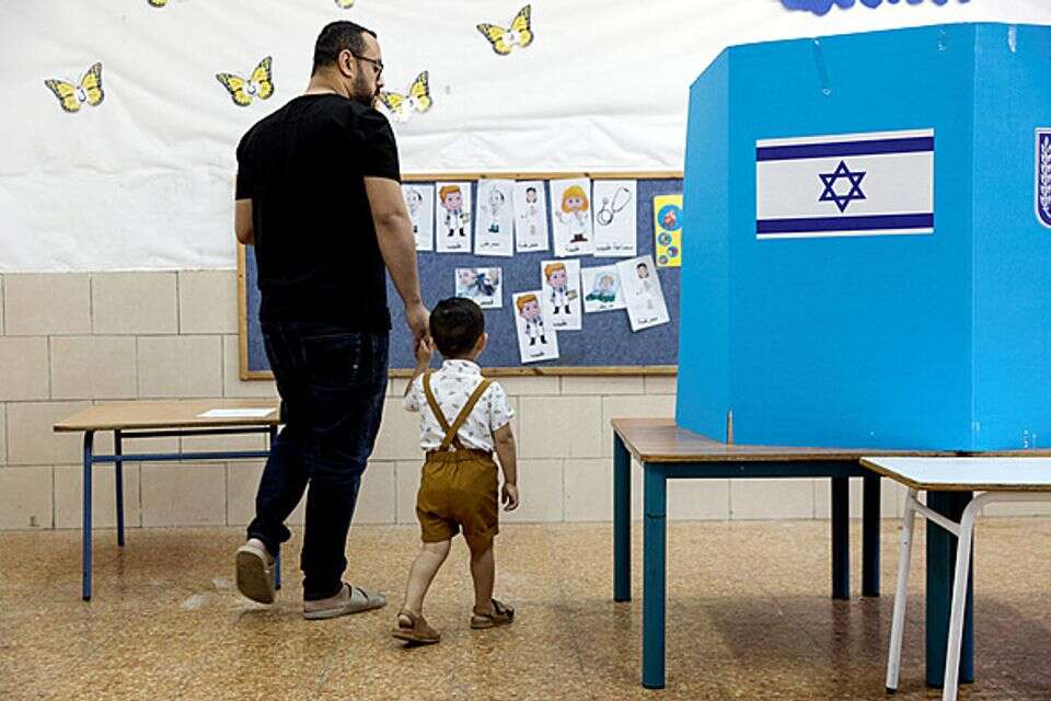 אב ובנו נכנסים לקלפי בבחירות הקודמות (ארכיון)  , רויטרס